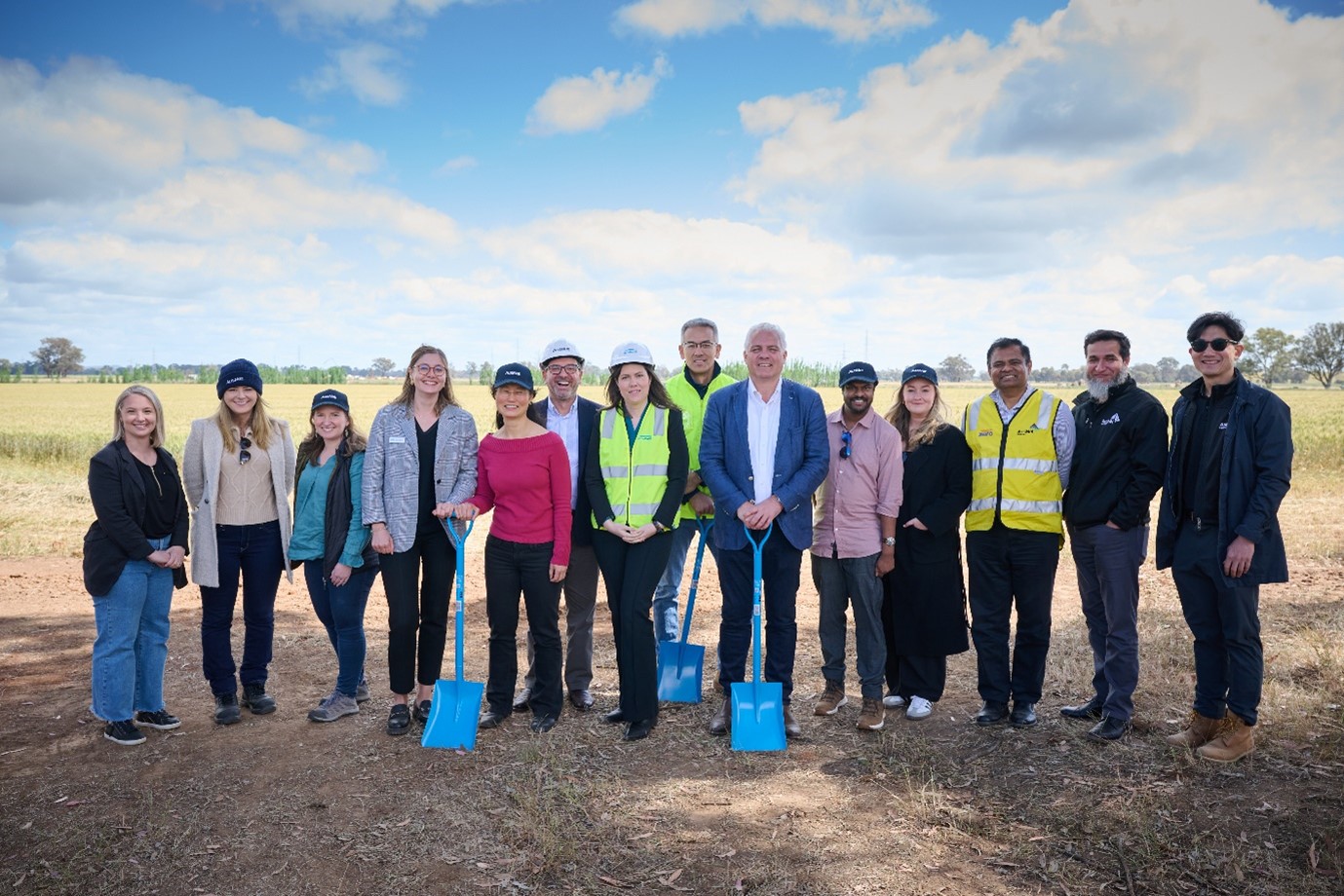 A large group of people standing outside in a dirt field