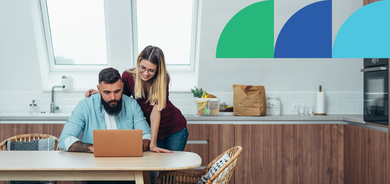 A couple inside looking at laptop together