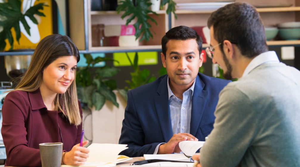 A group of people sitting at a table talking